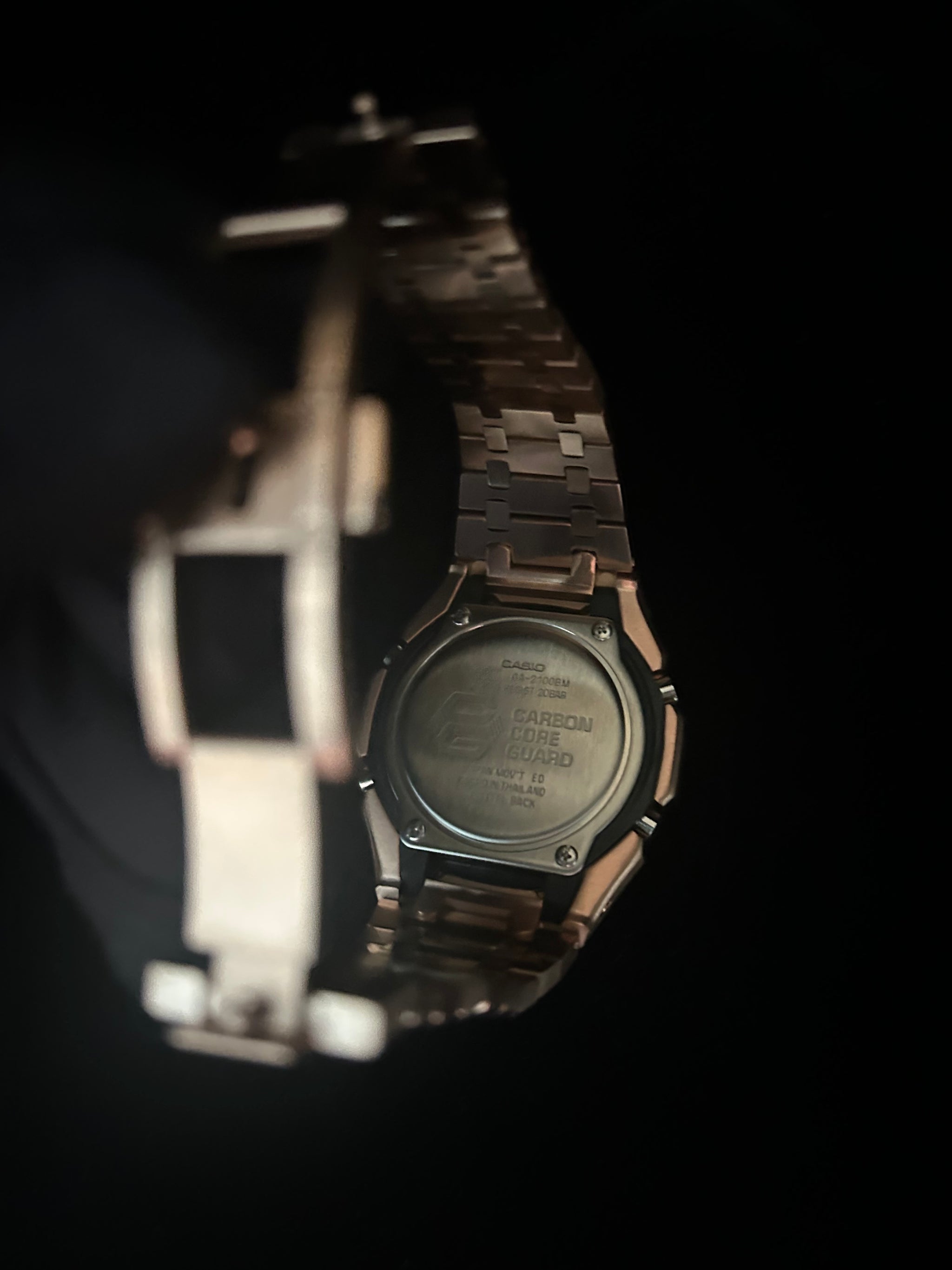 Digital wristwatch with metallic band on a dark background