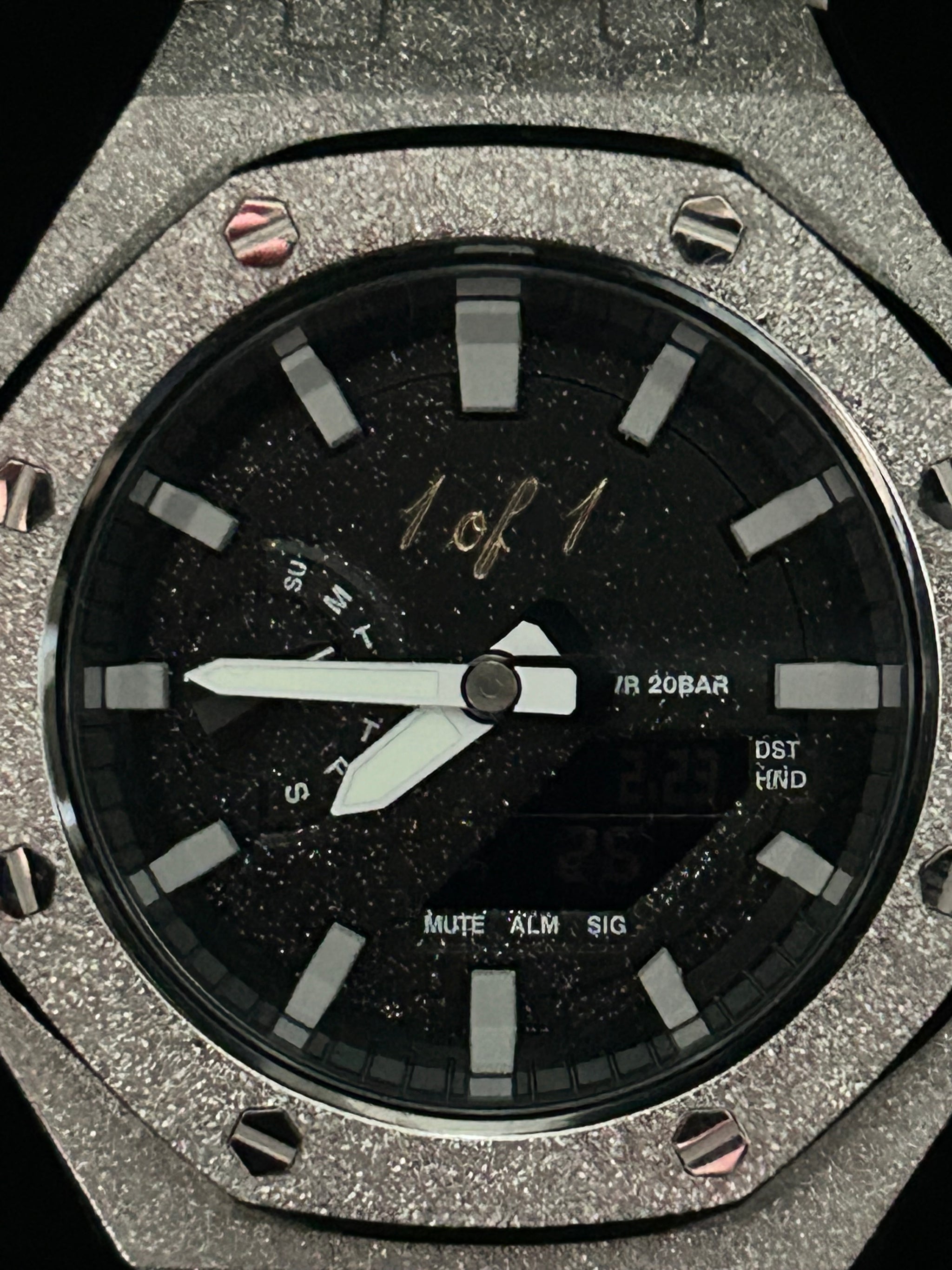 Close-up of a luxury watch with a black face and silver case.
