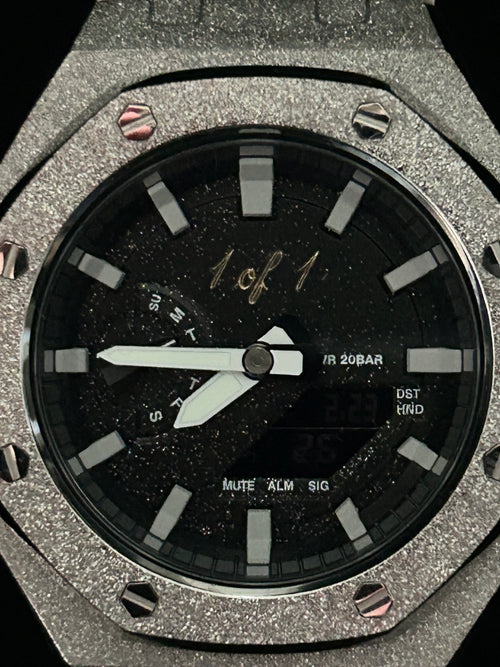 Close-up of a luxury watch with a black face and silver case.