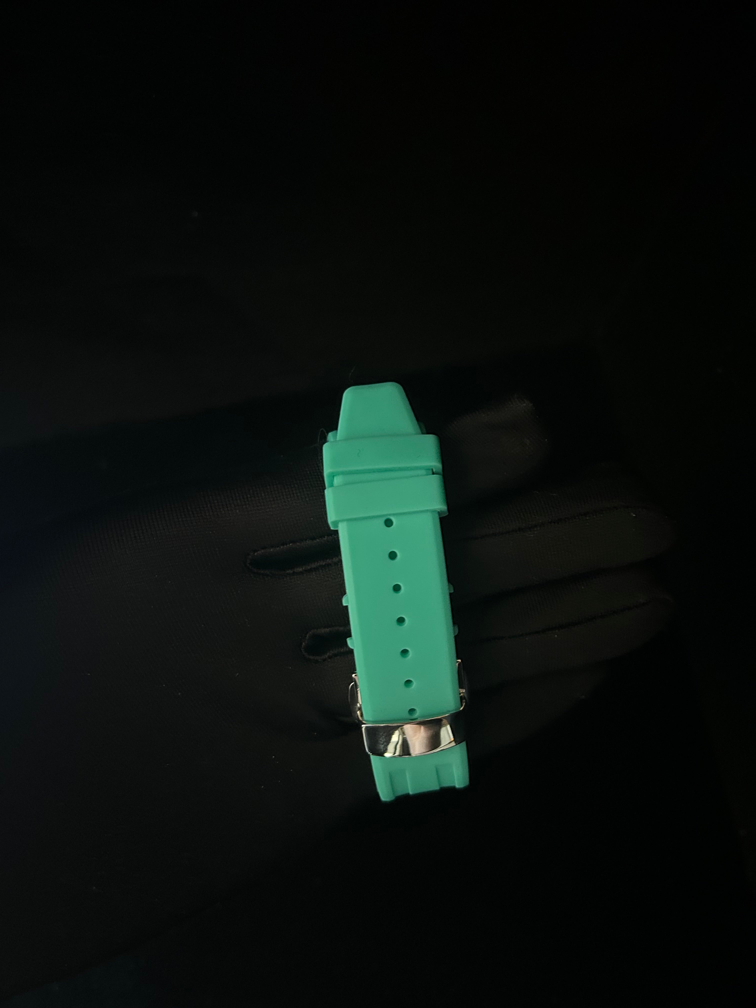 Green watch strap on a black background