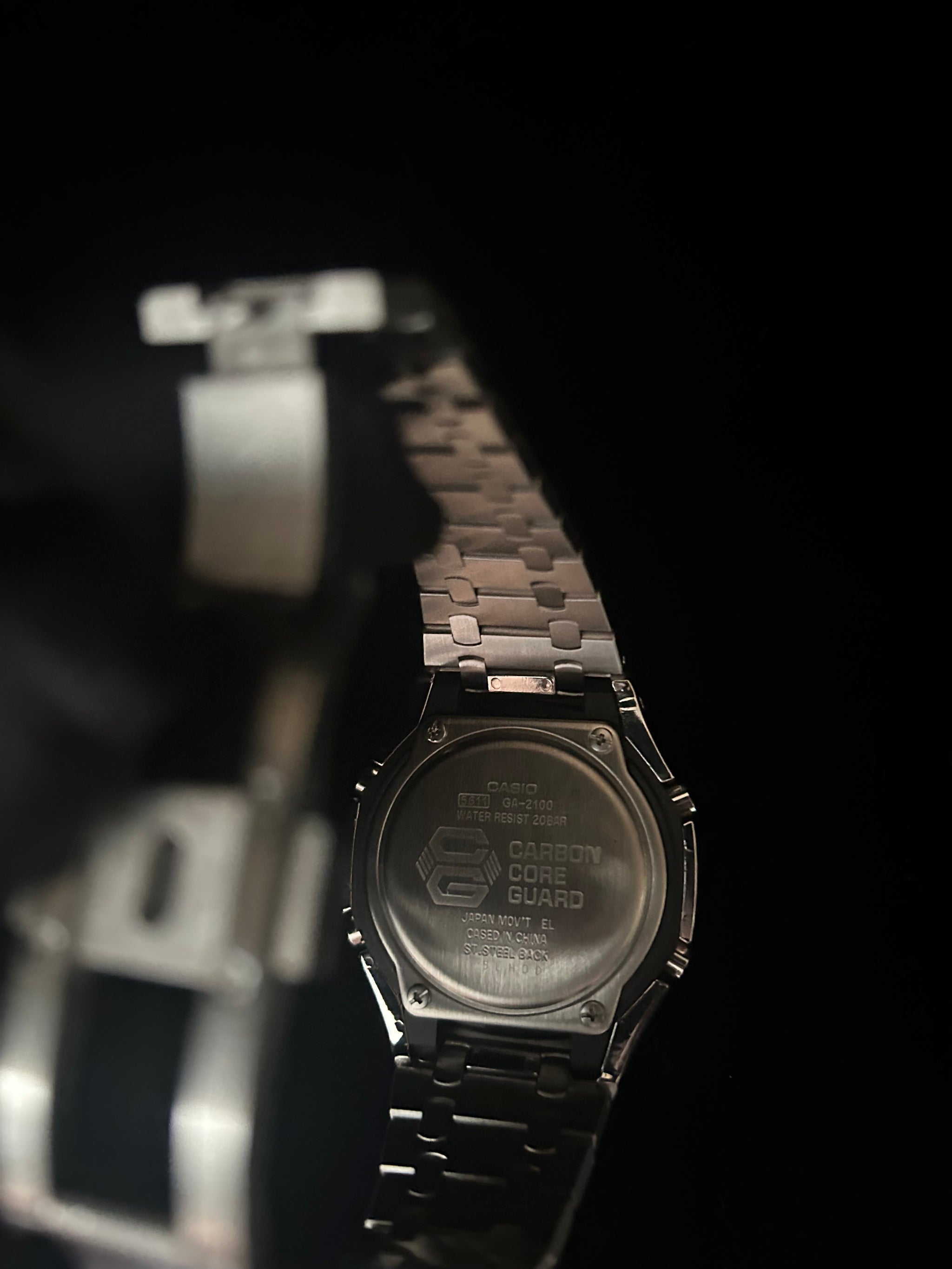 Close-up of a metallic watch with a dark background