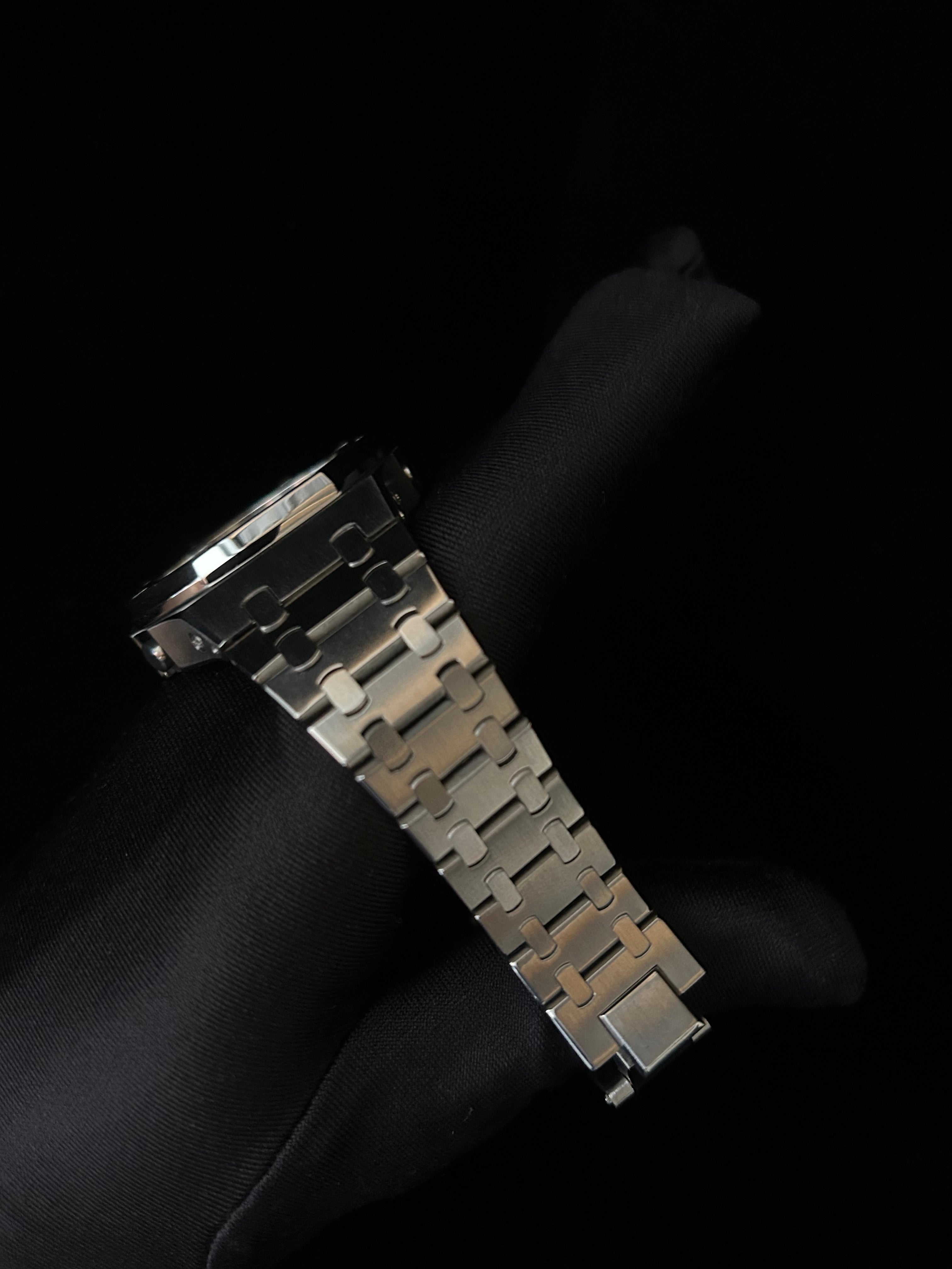 Metallic watch strap on a black background